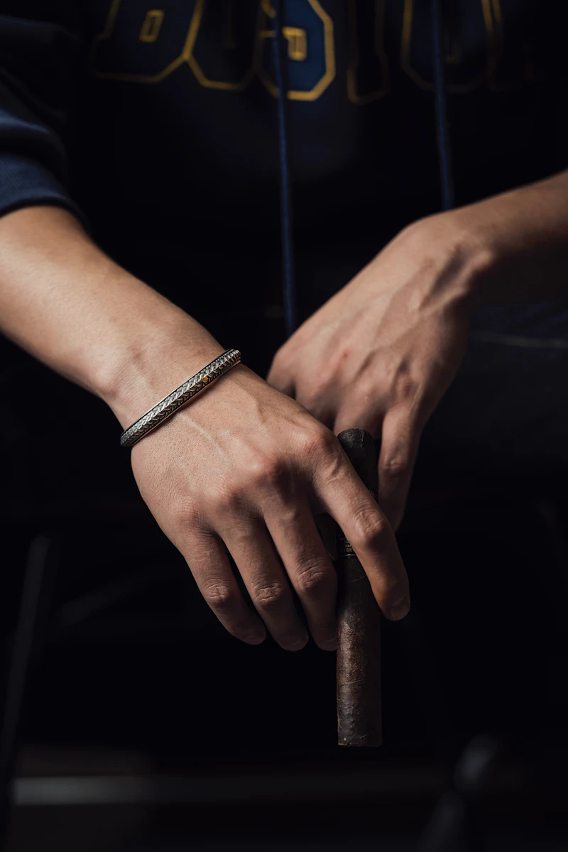 Adult hands in low light, one wrist wearing a slim diamond bracelet