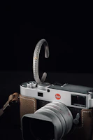 A silver crescent moon cradling a vintage camera, representing heartfelt vlog moments.