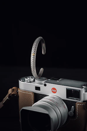 A silver crescent moon cradling a vintage camera, representing heartfelt vlog moments.