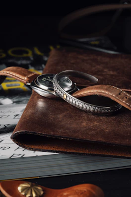 Luxury watch showcased beside a vintage compass and leather-bound book.