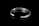 A silver bracelet with embossed patterns resting on a glossy black surface. The inside of the bracelet is engraved with the text 'COPPERTIST.WU' and a series of numbers. The bracelet has an open-ended design and the surface reflects light, enhancing its lustrous appearance.