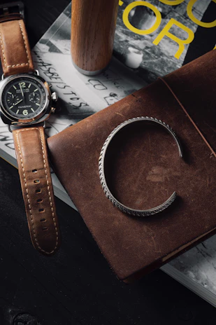 A stylish bracelet with subtle violet accents placed beside a mint-colored notebook.