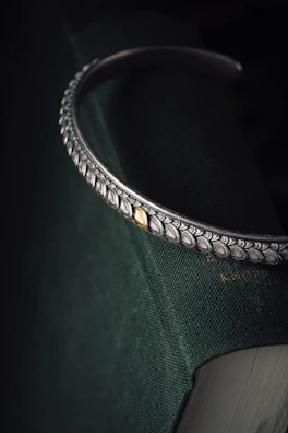 Laser-cut metal bookmark with an intricate, nature-inspired design.