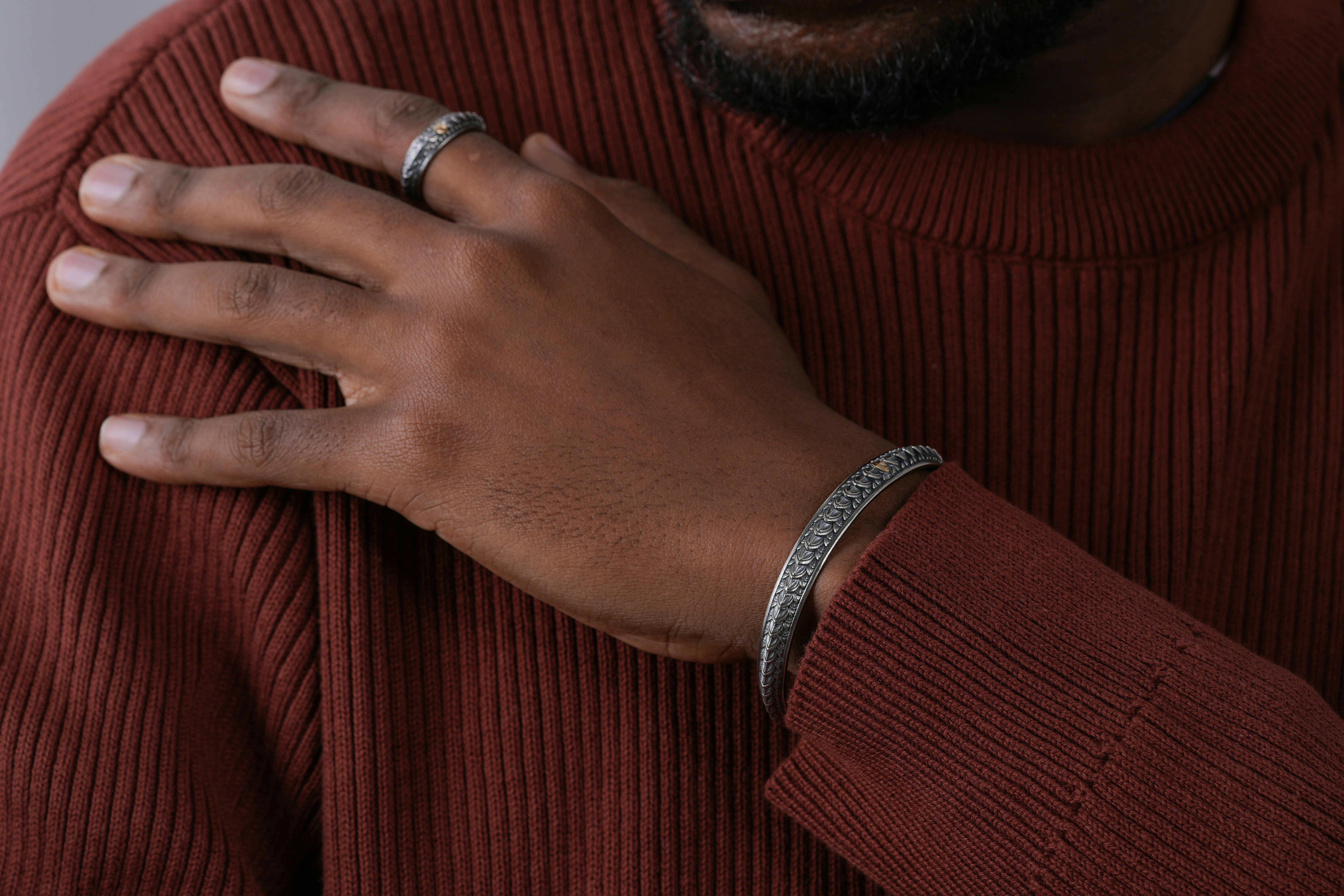 Man measuring his wrist with a flexible tape measure to ensure a perfect fit for a new bracelet
