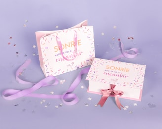 a pink and white box with a pink ribbon and a pink box with a pink