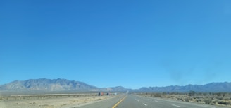 A taxi driving on an open highway with desert landscapes in the background