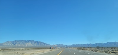 A taxi driving on an open highway with desert landscapes in the background