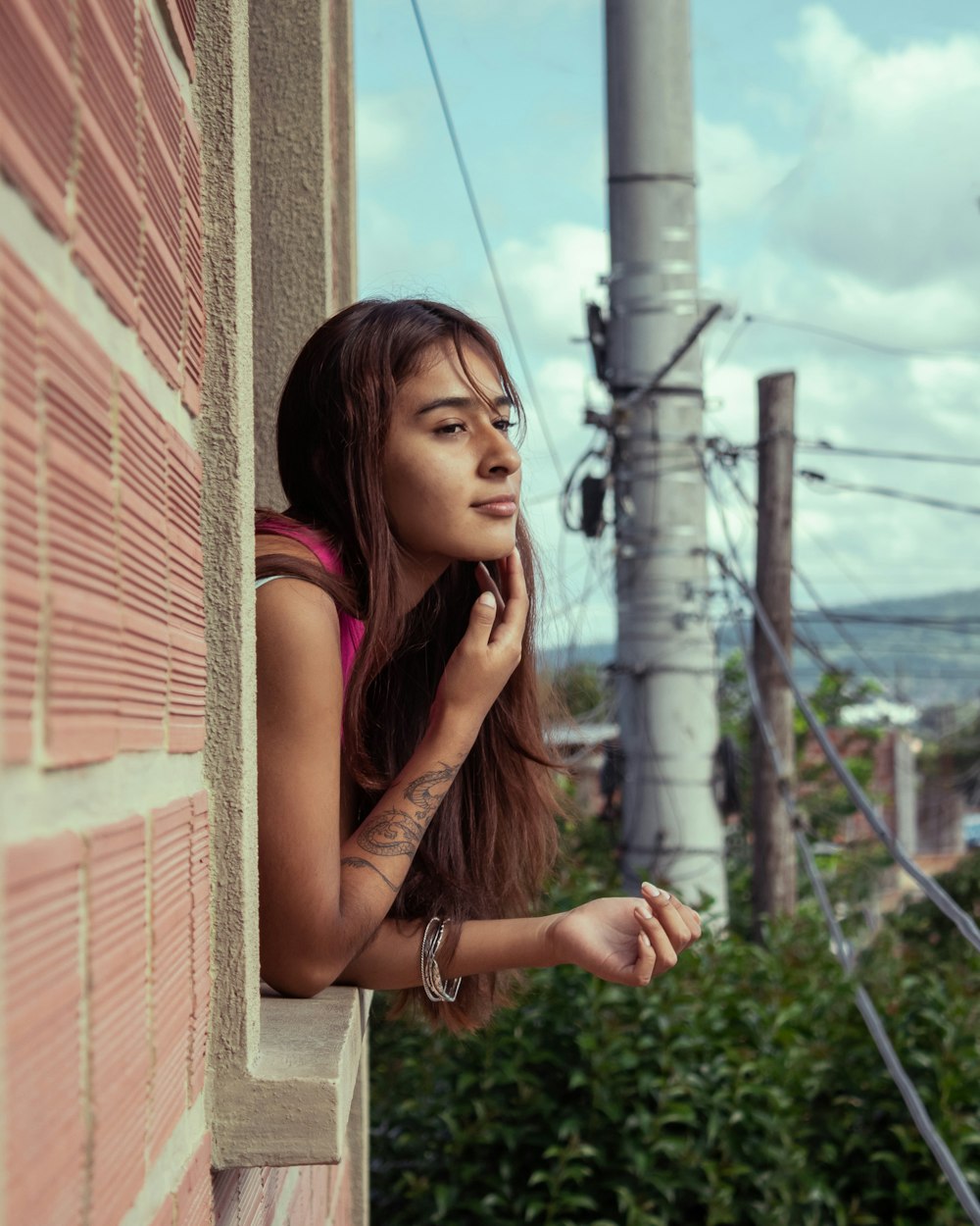 a woman leaning against a wall talking on a cell phone