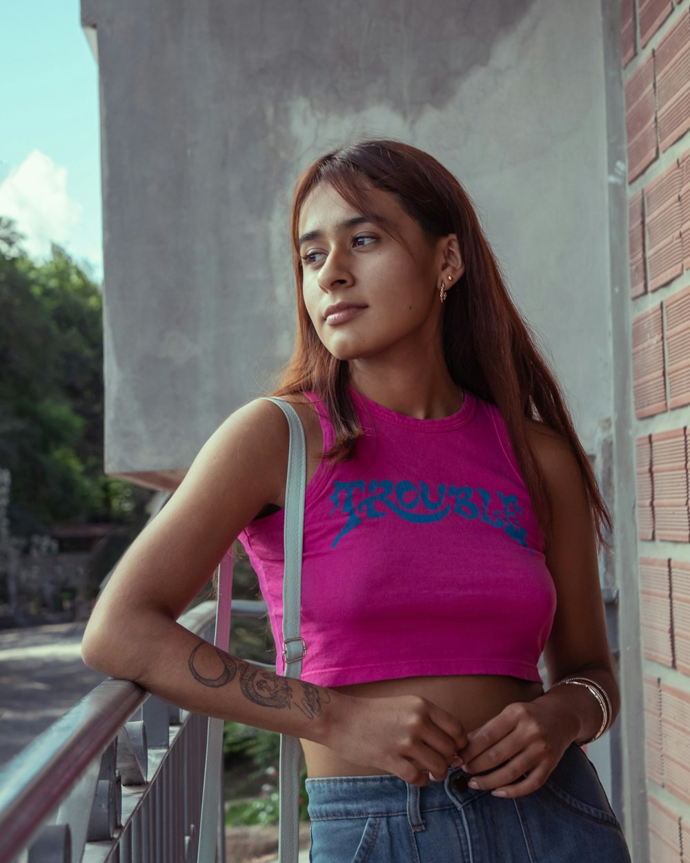 a woman standing next to a brick wall