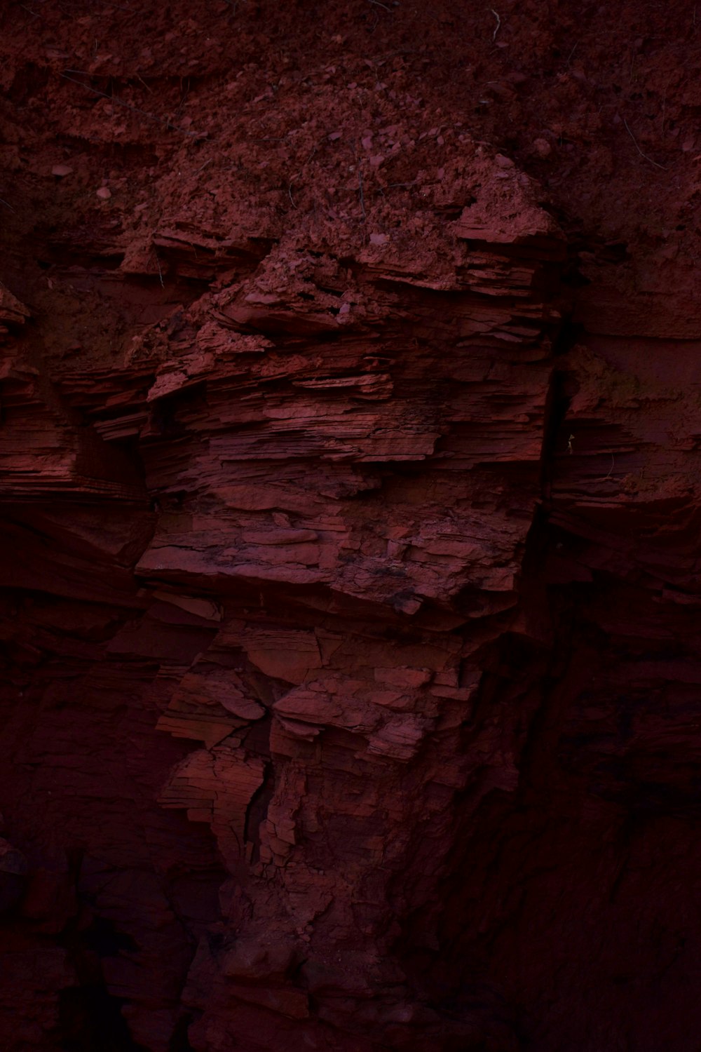Una formación rocosa roja con un cielo rojo en el fondo
