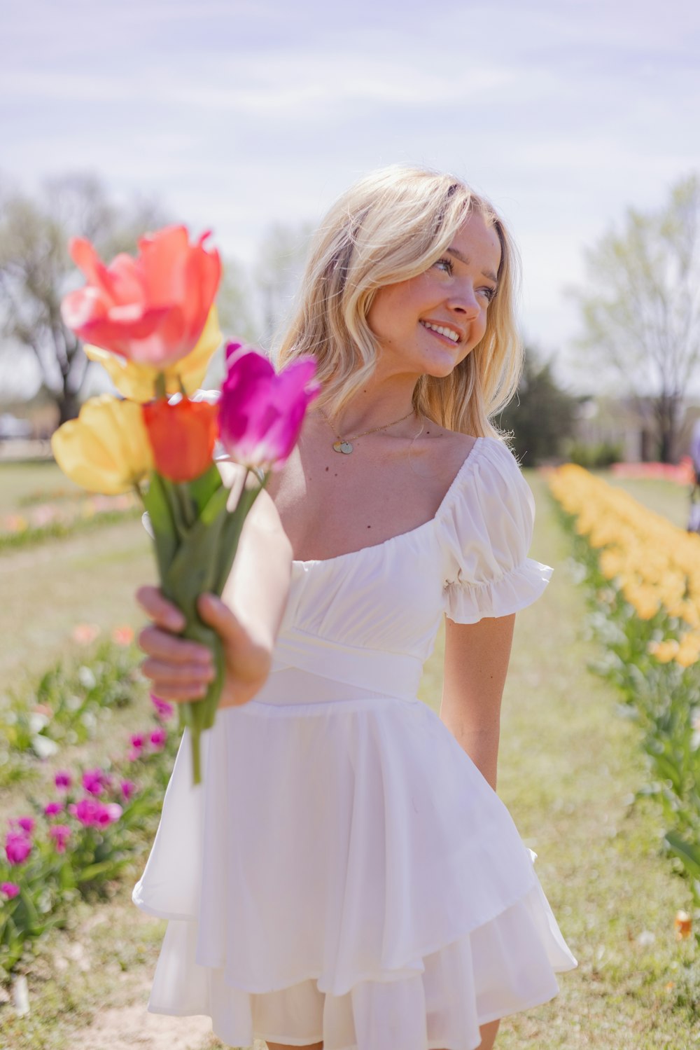 a woman in a white dress holding a bouquet of flowers