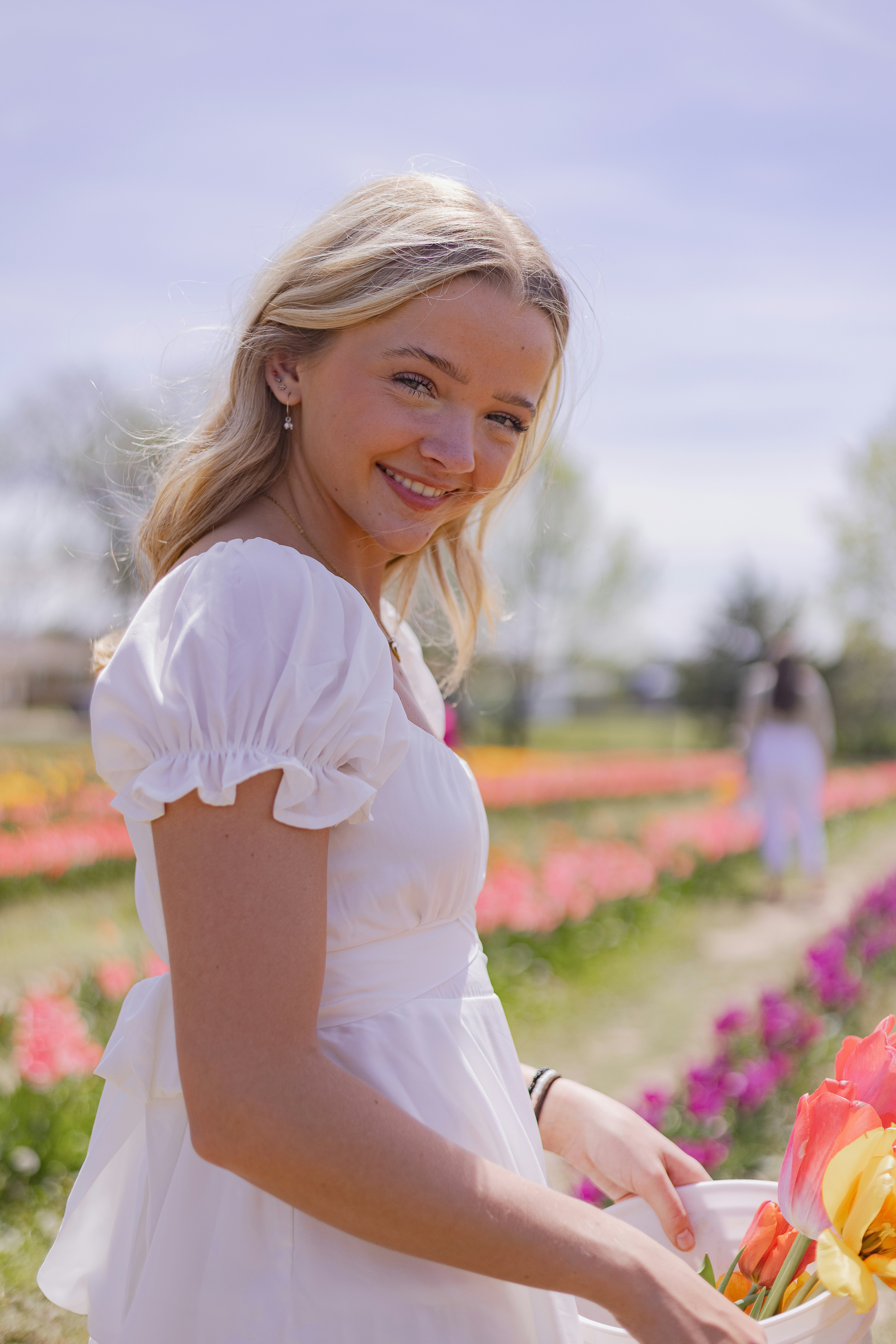 a woman in a white dress holding a bouquet of flowers