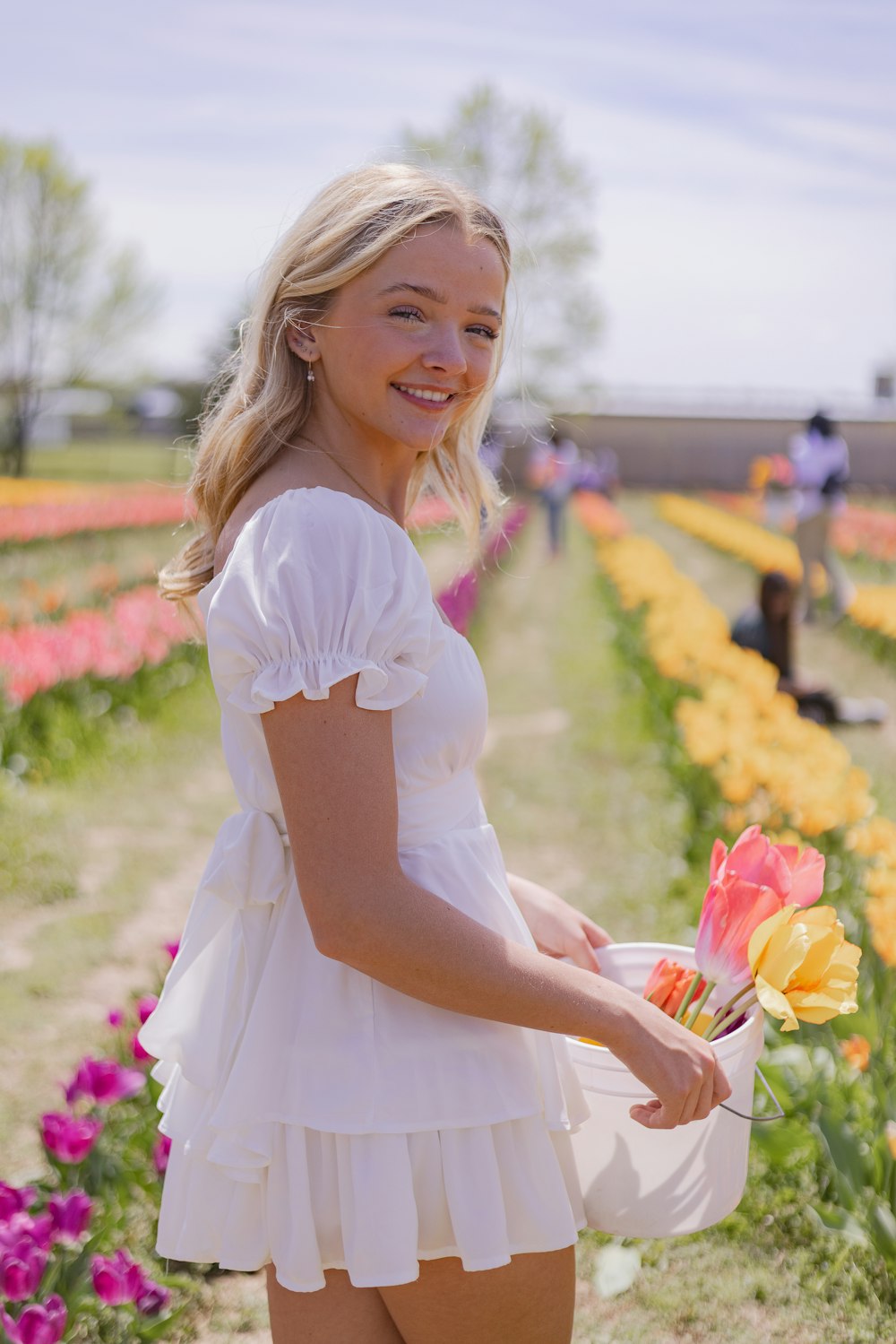 a woman in a white dress holding a bouquet of flowers