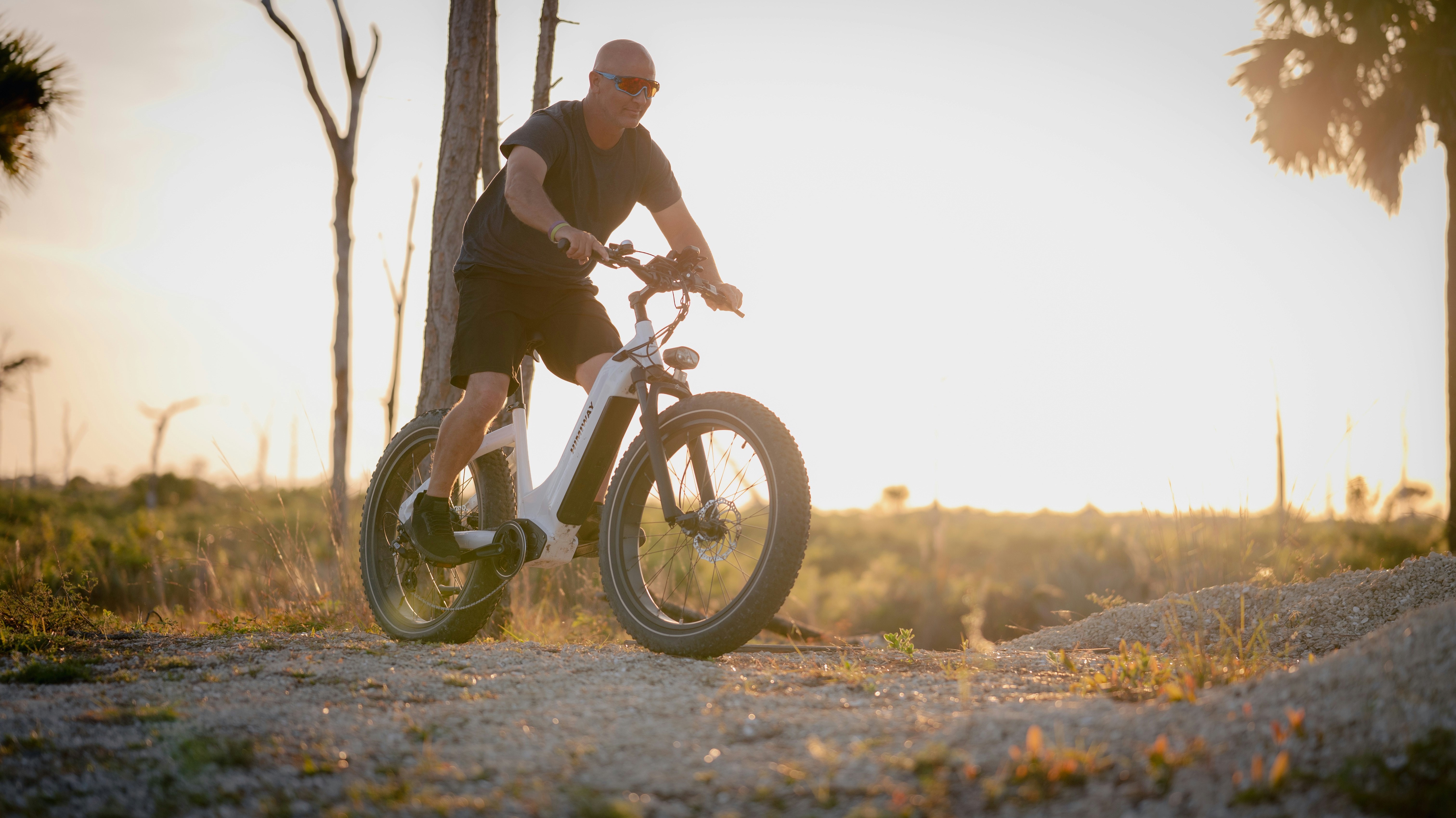 a man riding a bike down a dirt road