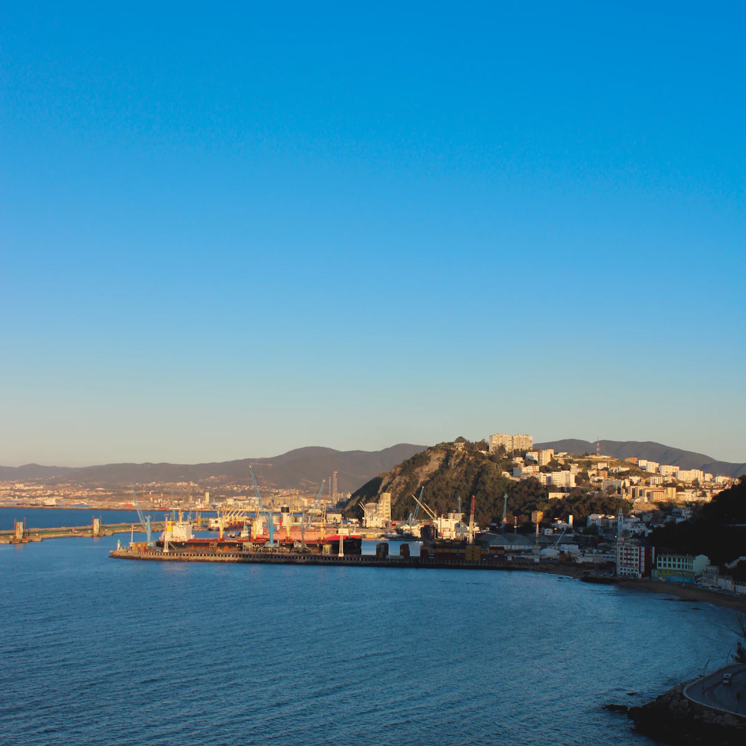 Port of Skikda, Algeria, in warm evening light under a clear blue sky