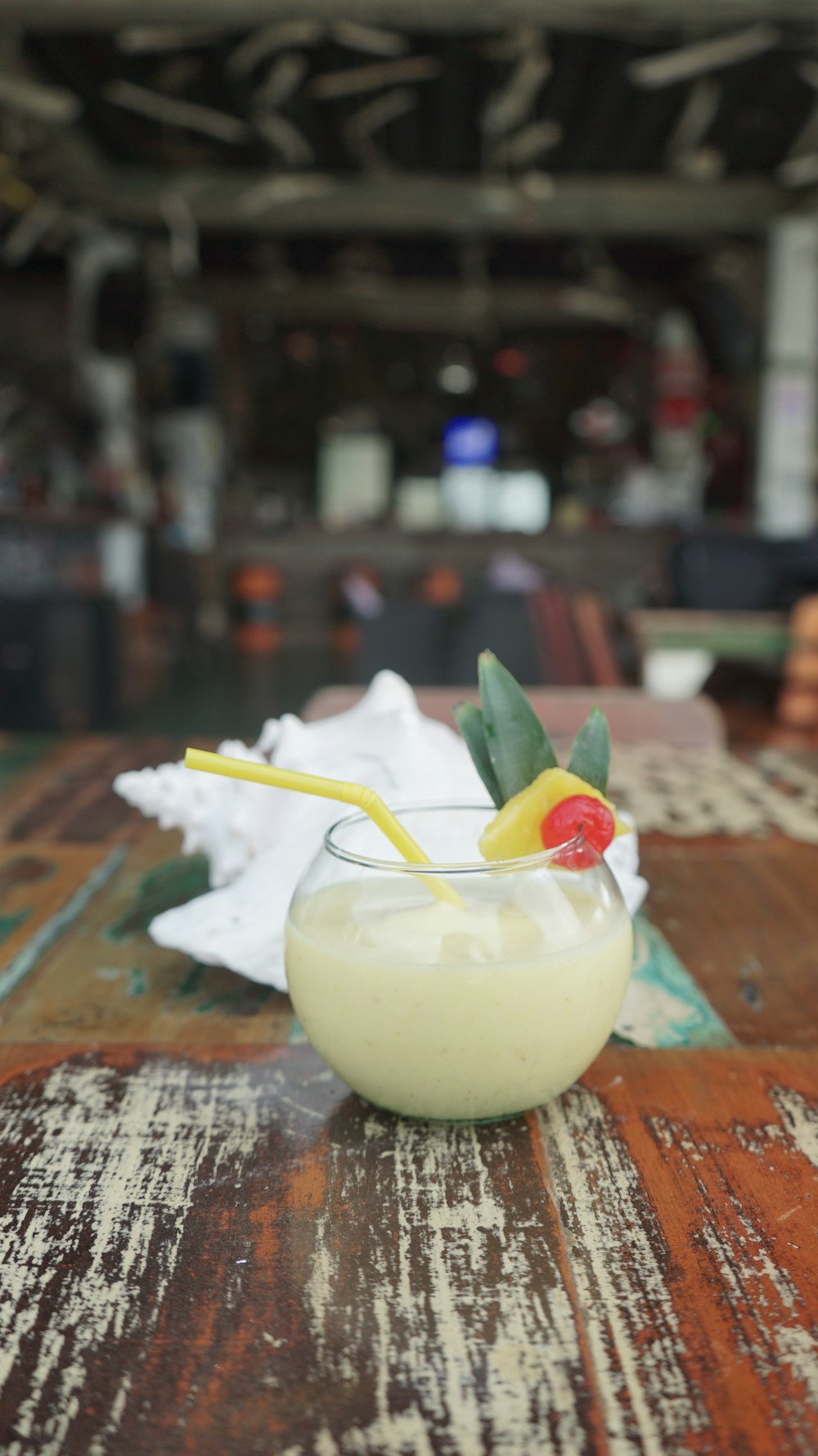 a glass filled with a drink sitting on top of a wooden table