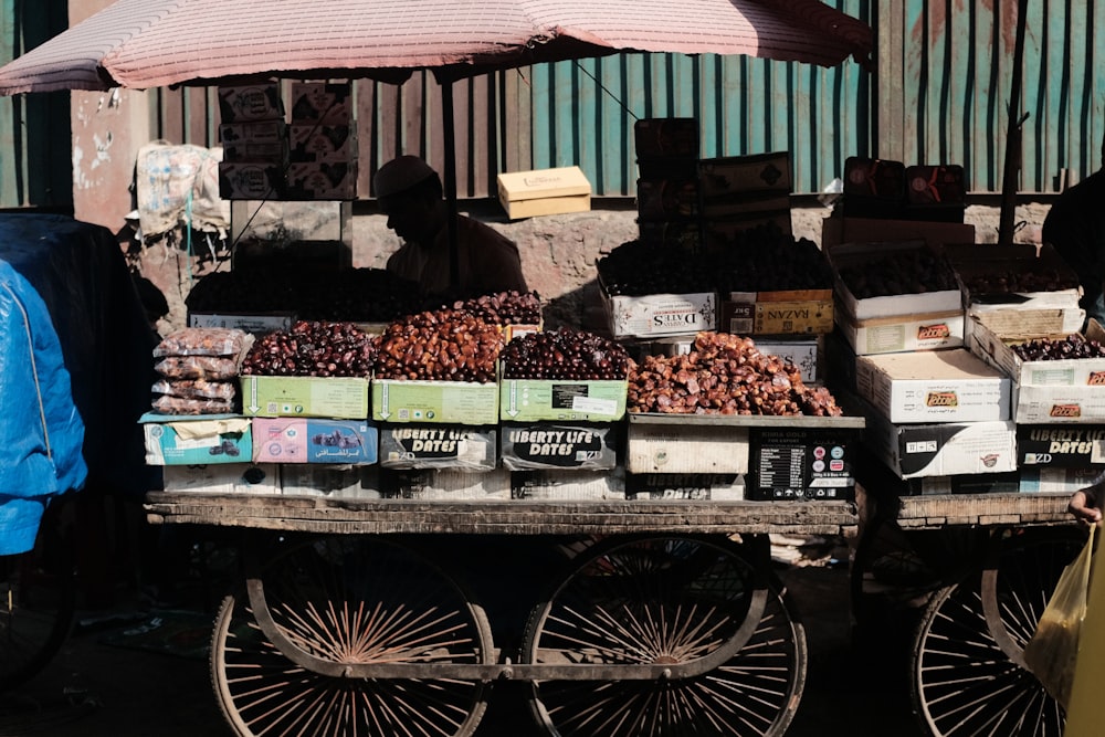 a man standing next to a cart filled with fruit