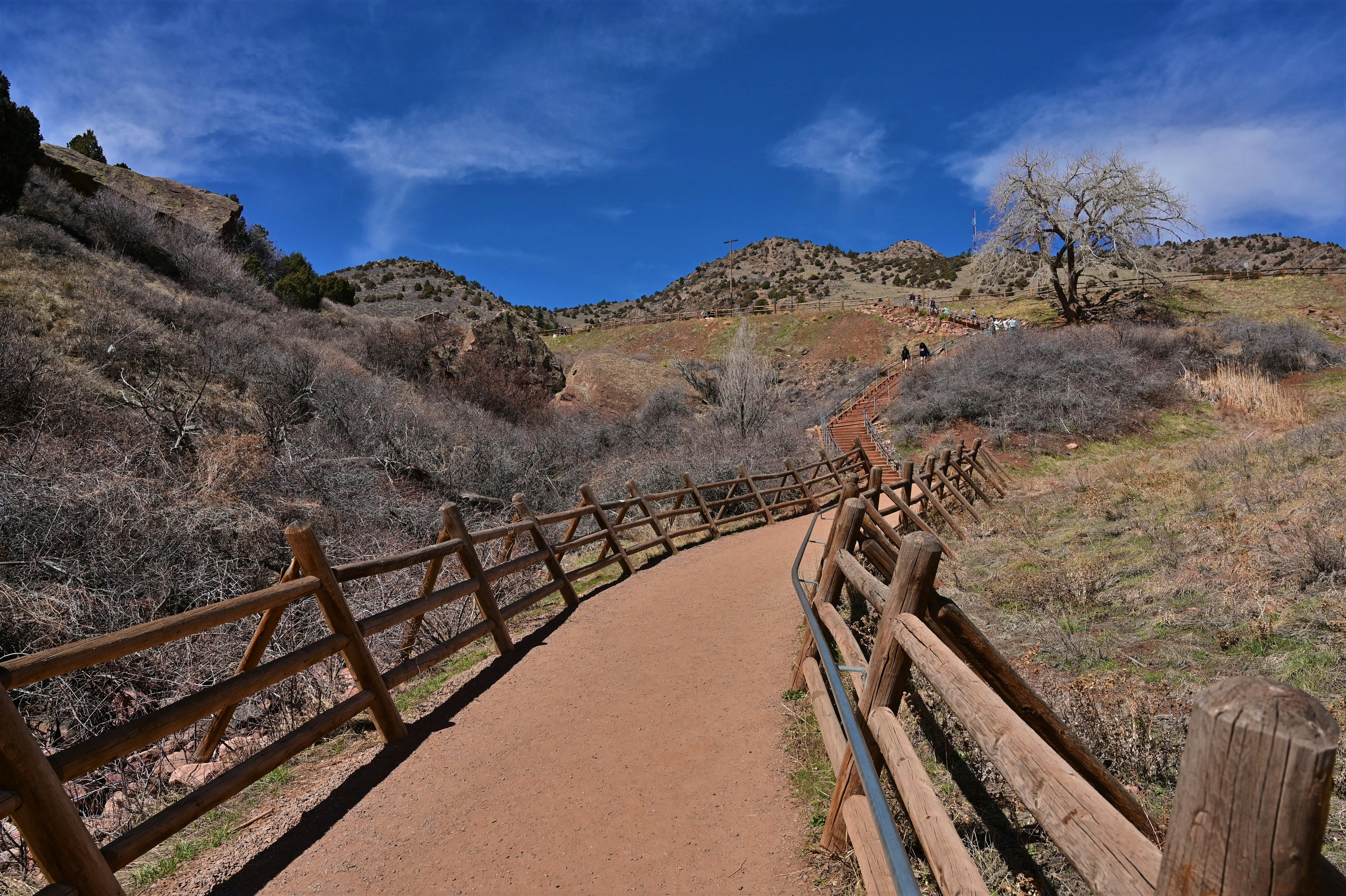 a dirt path with a wooden fence on the side of it