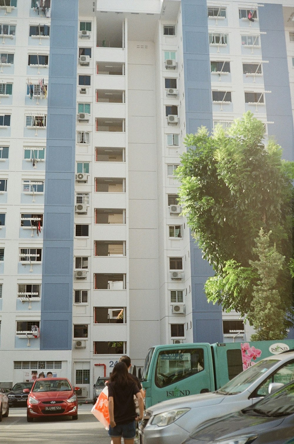 a woman walking down a street in front of a tall building