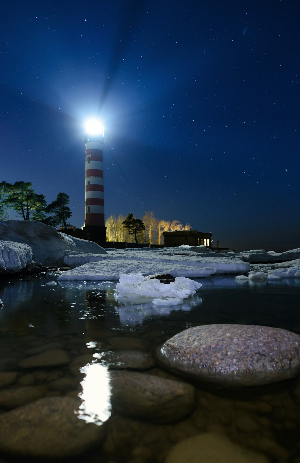 a lighthouse on a rocky shore at night