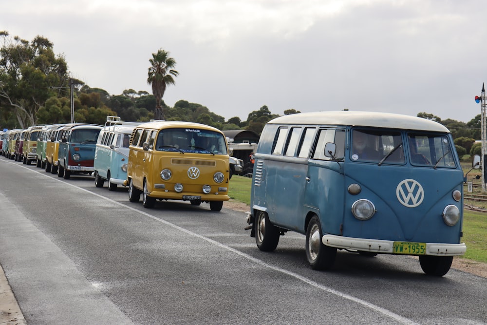 a row of vw buses driving down a street