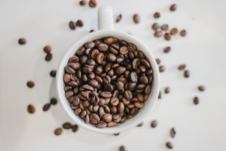 a cup filled with coffee beans on top of a table