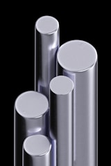 A cluster of shiny, metallic cylindrical bars standing upright against a black background. The bars have varying heights and diameters, reflecting light with a smooth, polished surface.