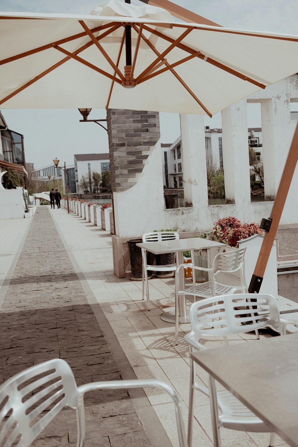 a row of white chairs sitting under an umbrella