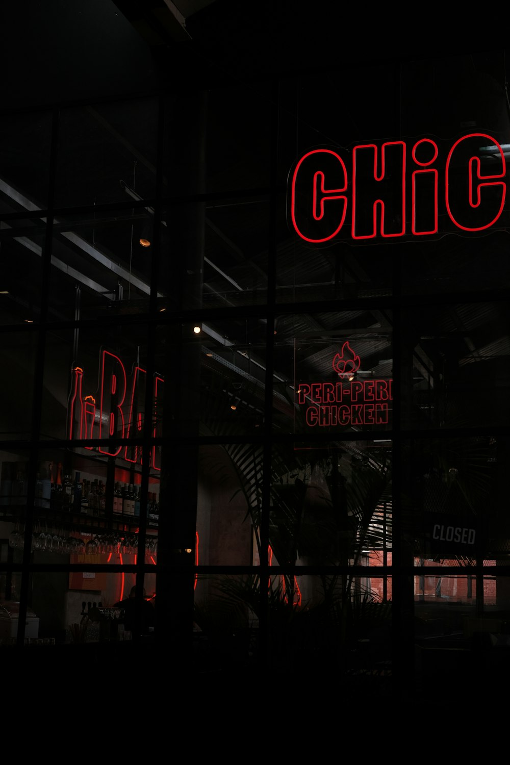 a neon sign is lit up in the window of a restaurant