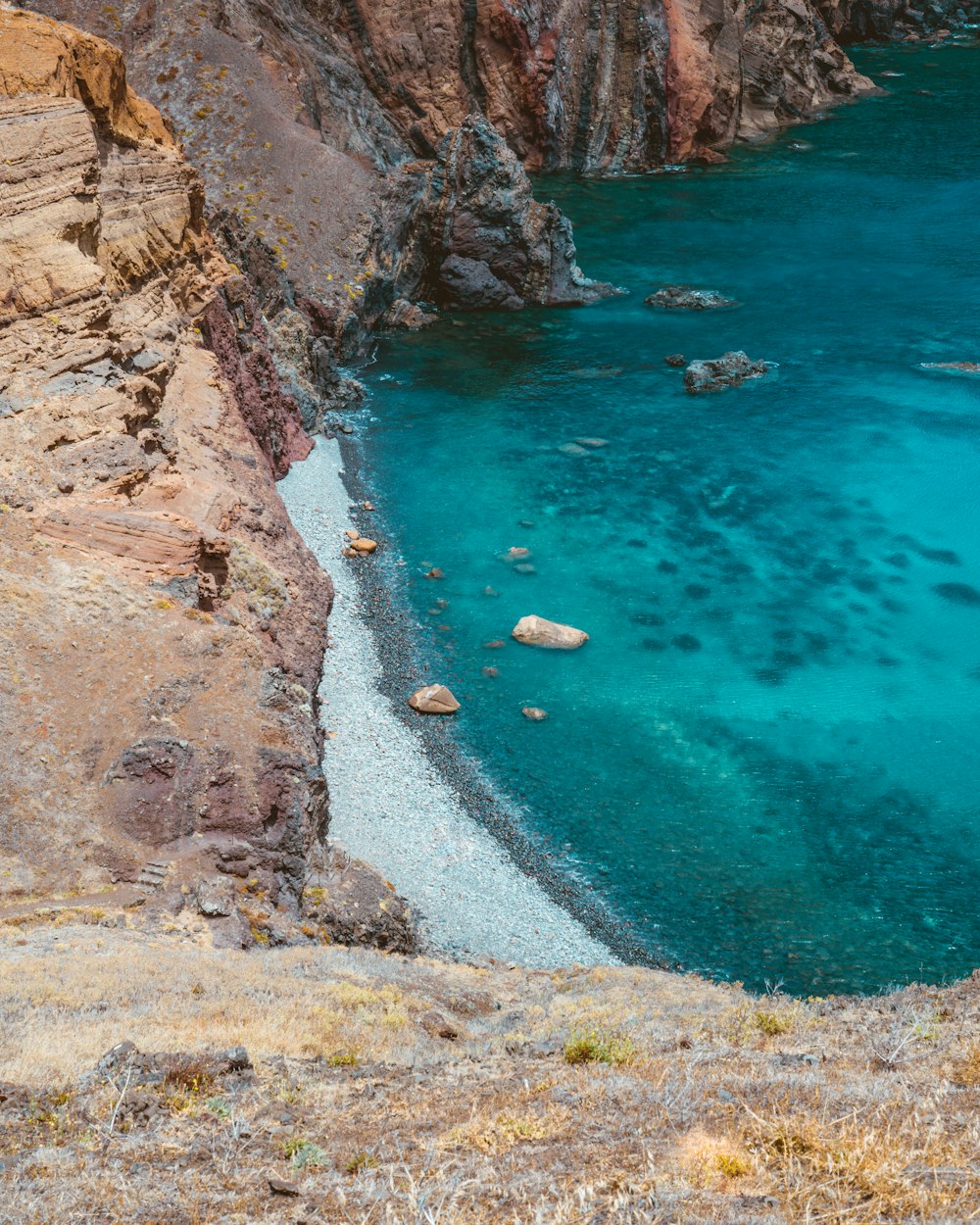 a body of water surrounded by a rocky cliff