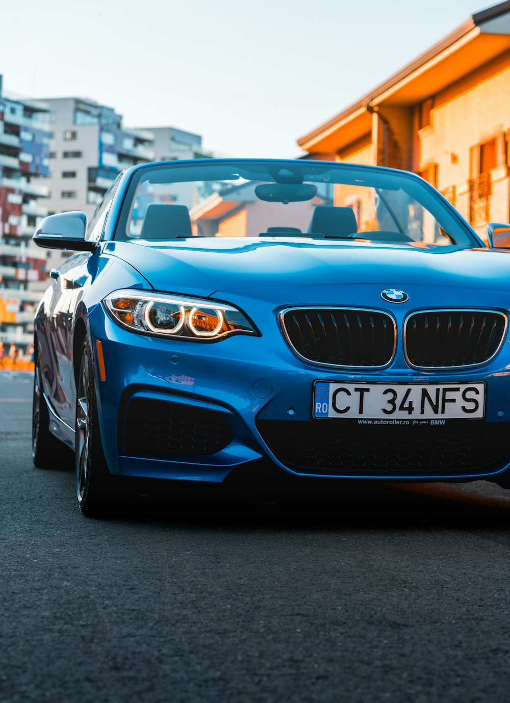 a blue sports car parked in front of a building