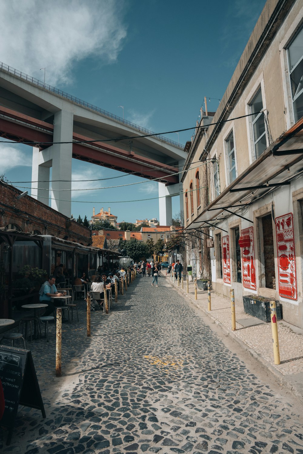 a cobblestone street with a bridge in the background