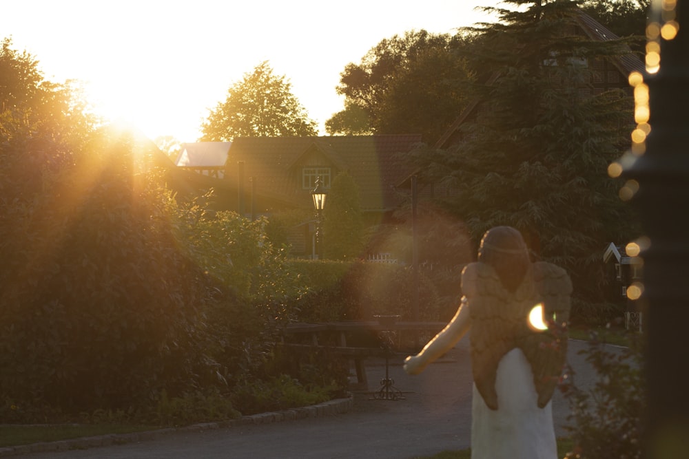 a bride and groom walking down a path at sunset
