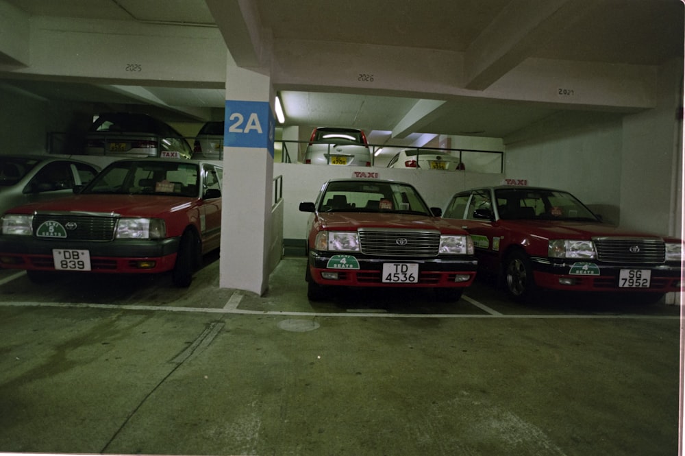 a couple of red cars parked in a parking garage