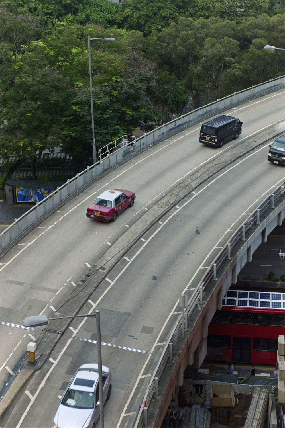 two cars are driving on a highway with a bridge