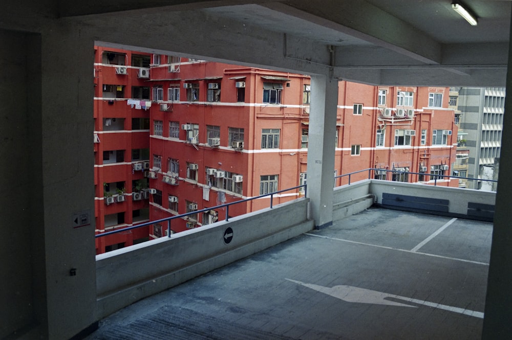 an empty parking lot with a red building in the background