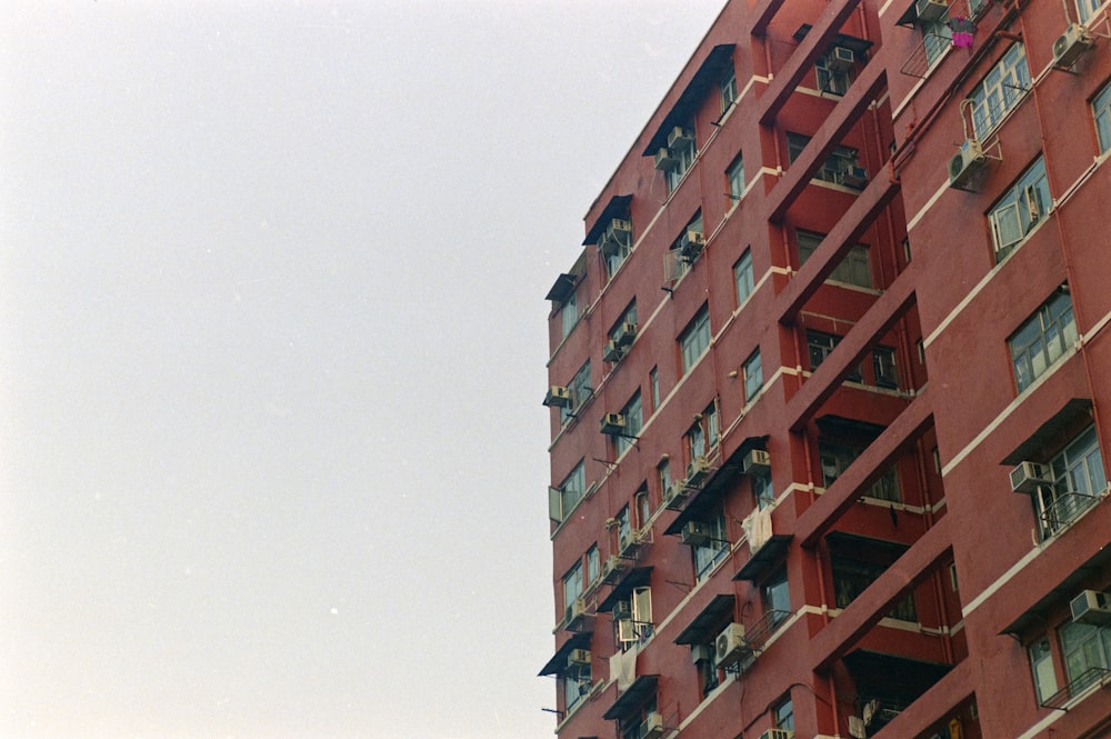 a tall red building with balconies and windows