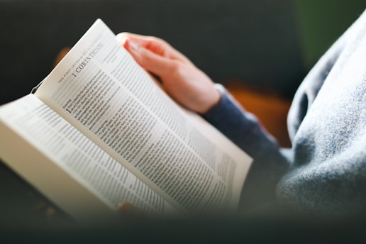 a person reading a book on a couch