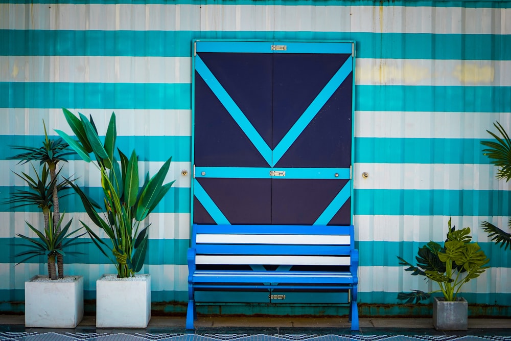a blue and white bench sitting in front of a blue door