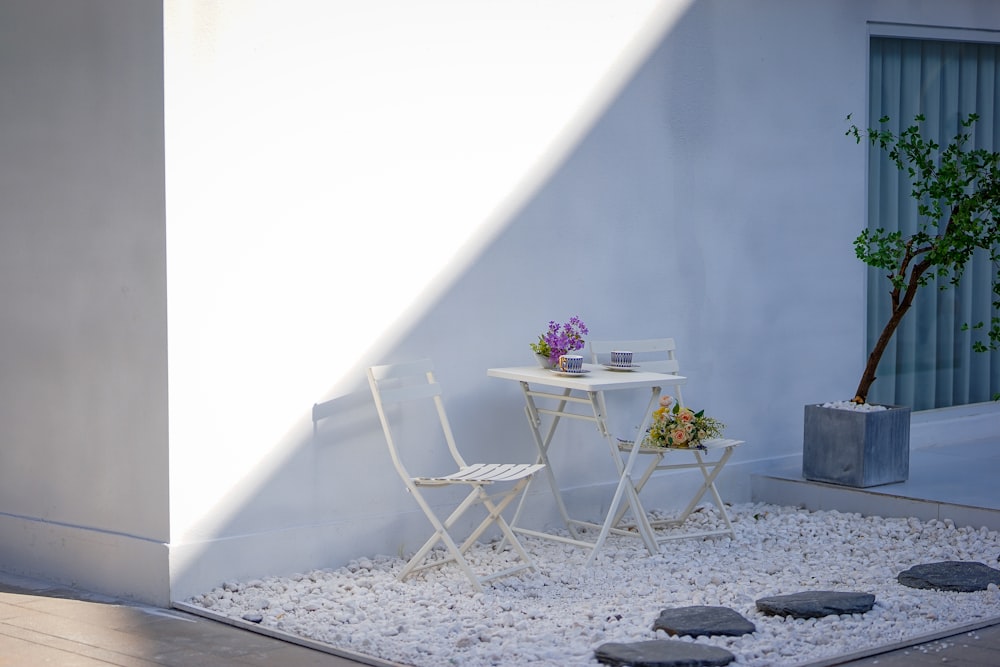 a white table and two chairs sitting on a patio