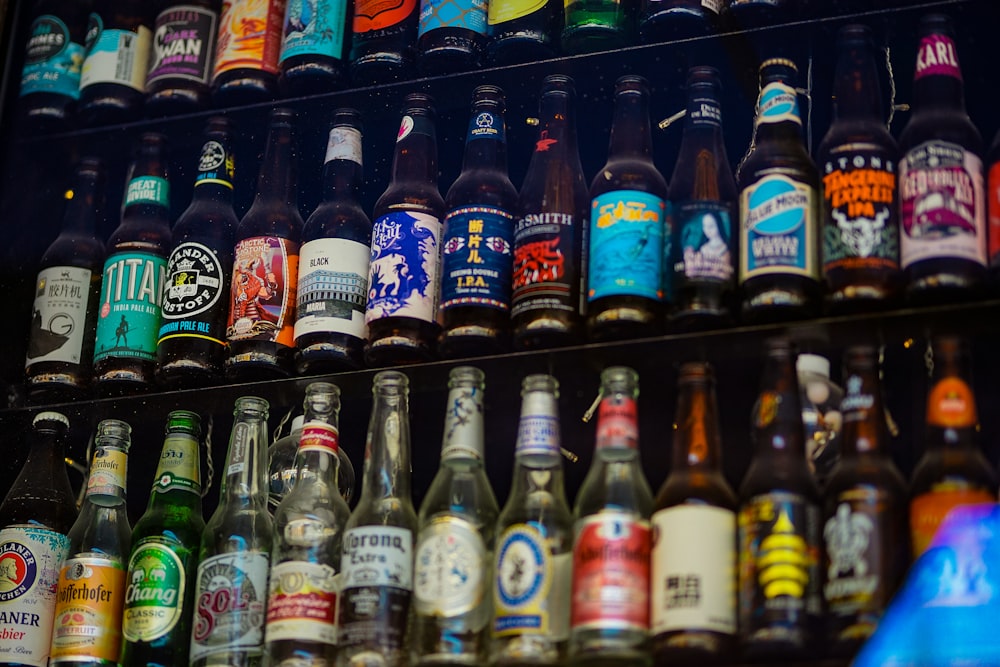 a bunch of beer bottles that are on a shelf