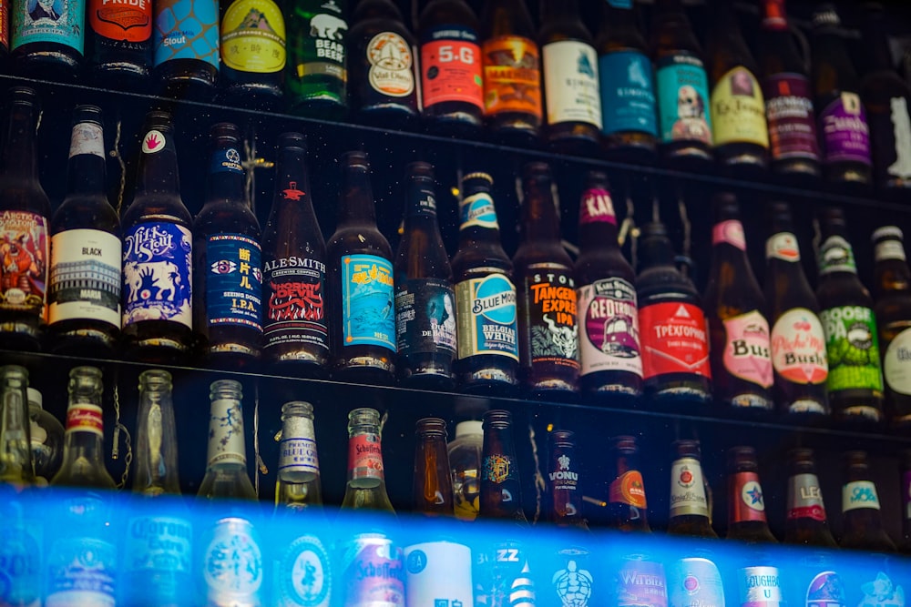 a bunch of beer bottles are stacked on a shelf