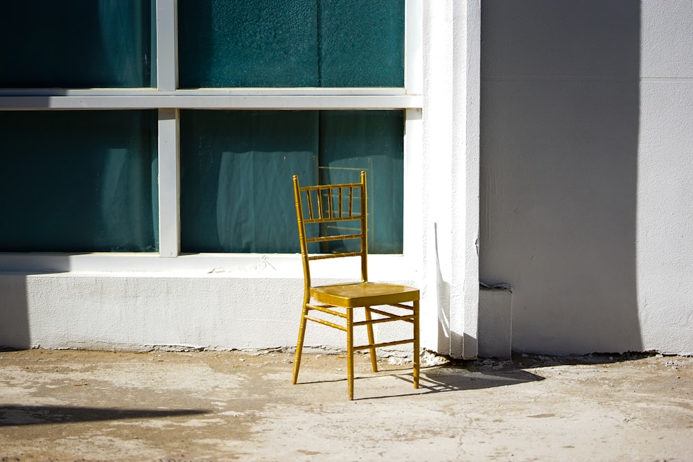 a yellow chair sitting in front of a window