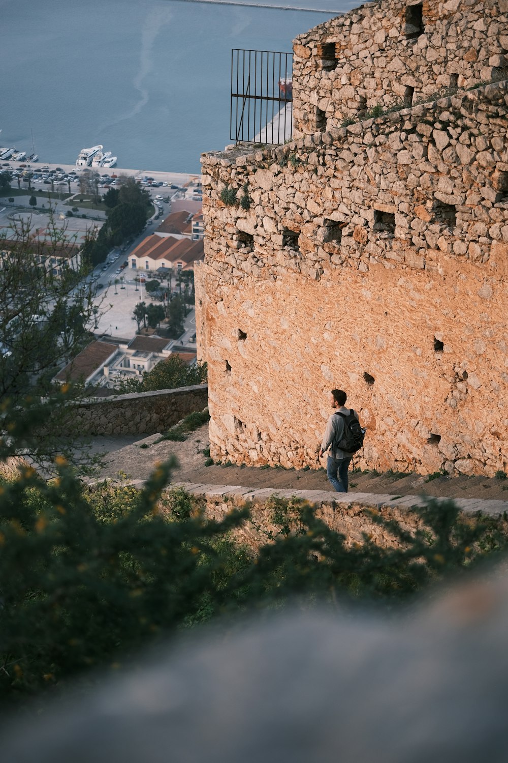 Un hombre parado frente a un muro de piedra