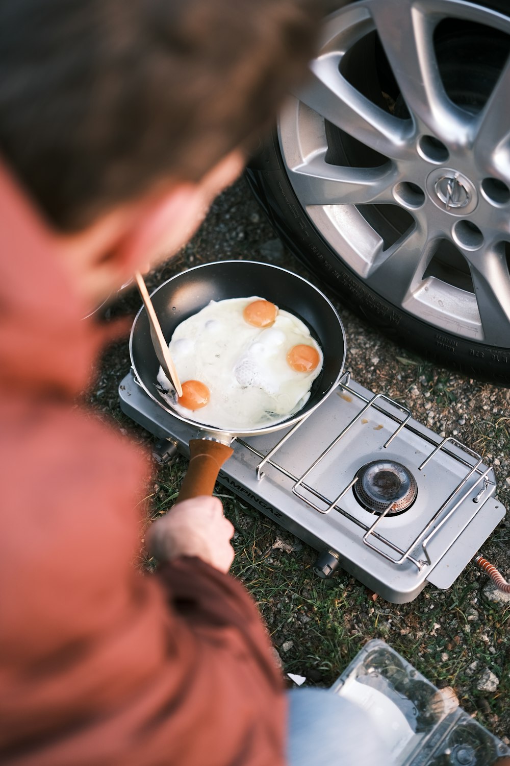 a man is cooking eggs on a stove
