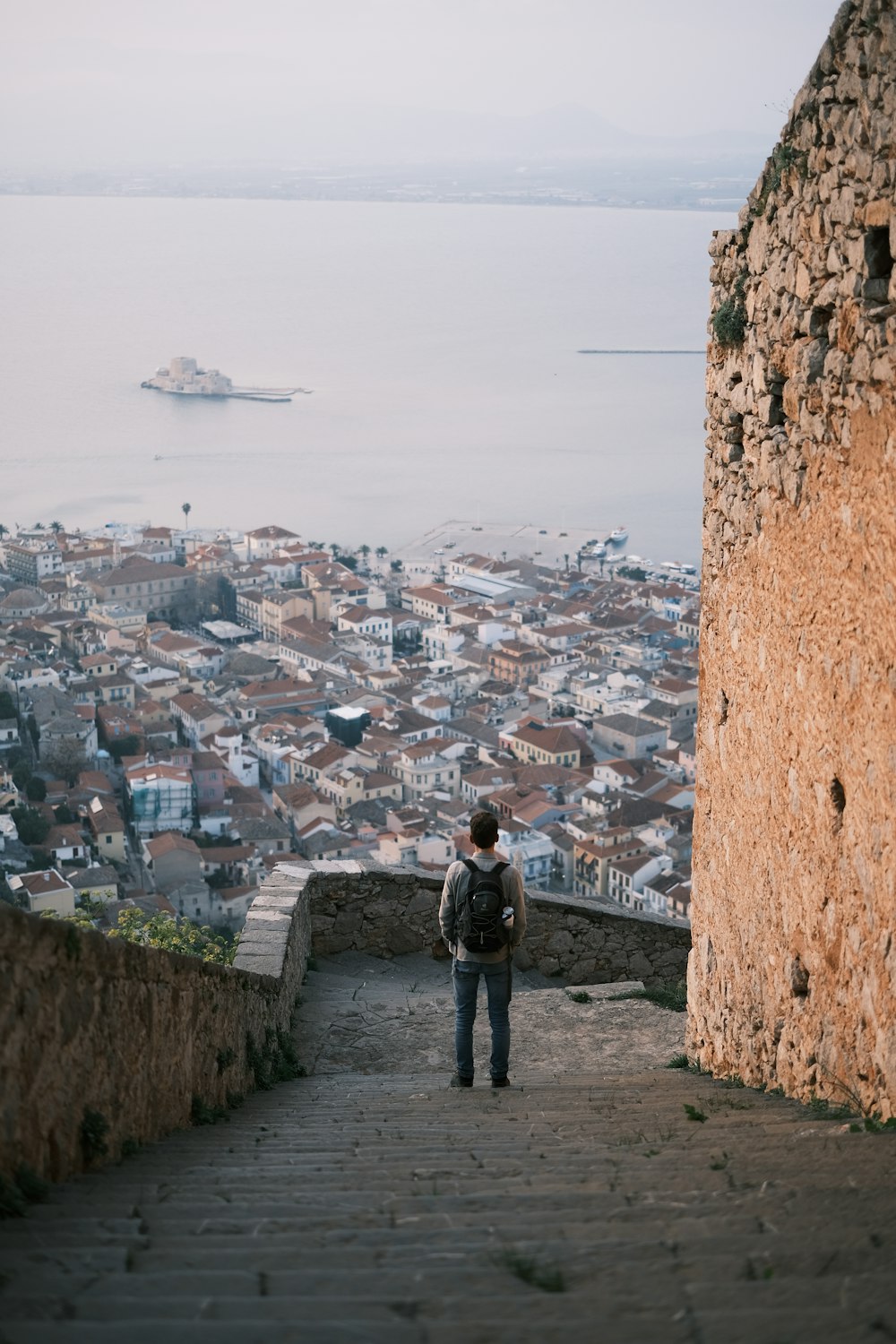 a person with a backpack standing at the top of a hill