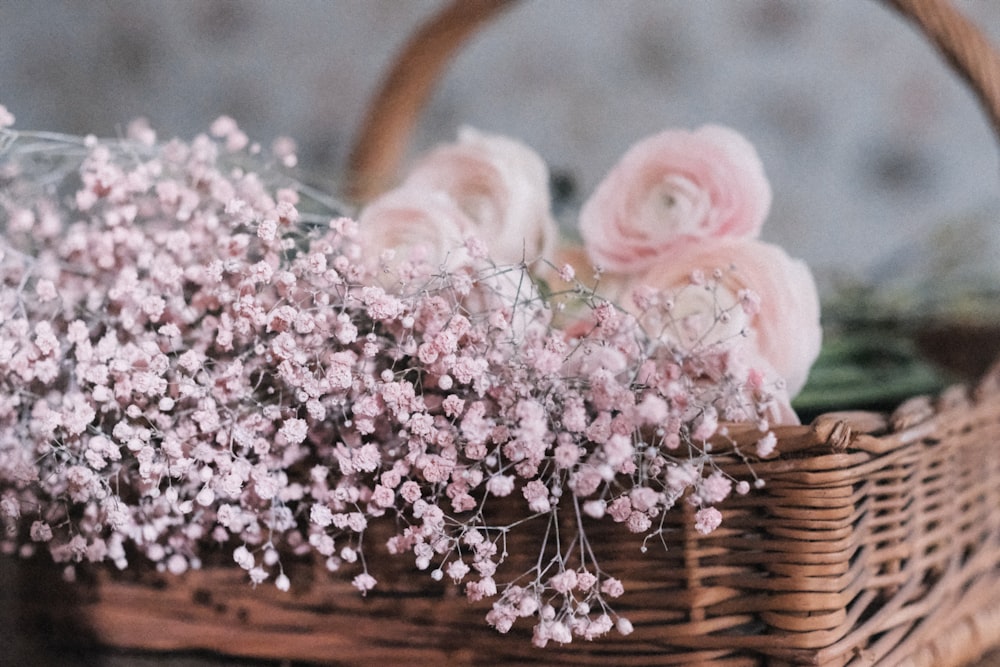 a basket filled with pink flowers sitting on top of a table