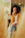 Plus size woman smiling confidently while wearing a beige elegant cardigan in a softly lit modern room