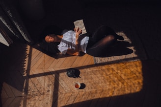 a woman laying on the floor reading a book