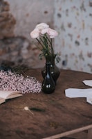 A rustic wooden table displaying the two growing volumes alongside fresh wildflowers.